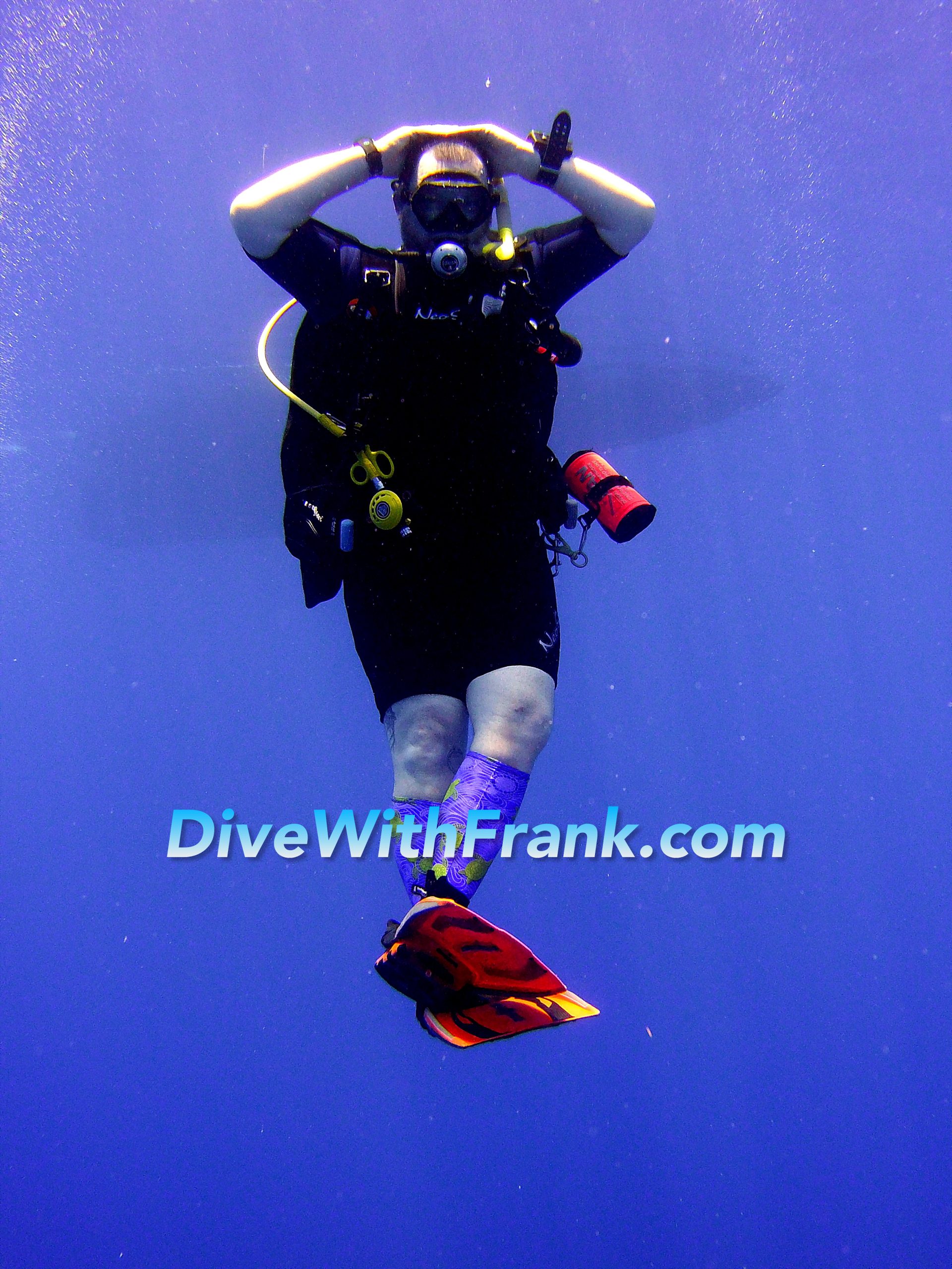 Scuba diver hovering vertically with ankles crossed in perfect, relaxed control