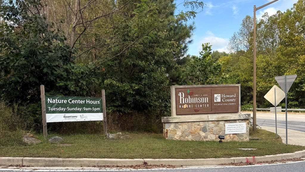 Entrance sign for Robinson Nature Center surrounded by trees.