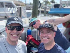 Two divers selfie on boat with photobomb