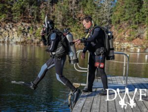 Diver performing a giant stride entry with instructor spotting