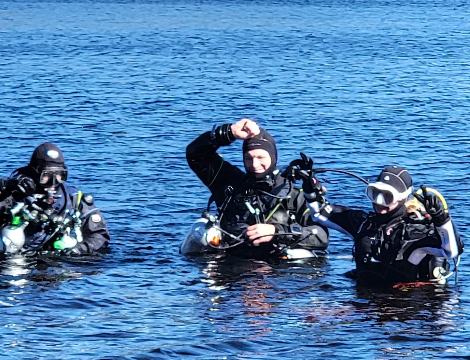 Divers floating at the surface in sidemount configuration during training drills.
