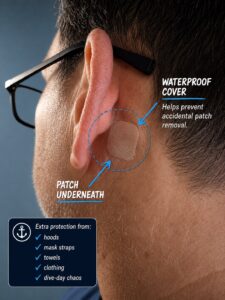 Close-up photo showing a waterproof Hydro Seal bandage covering a scopolamine patch behind the ear before scuba diving.